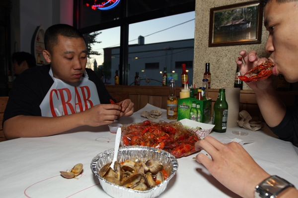 Patrons eating the Cajun Crawfish specialty and Trieu Dinh at Crawfish King in Seattle on Sunday May 3, 2009. (Kevin P. Casey/Seattle Weekly)