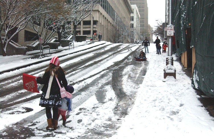 On steep Spring Street, slippery for cars even without the snow, the local daycare center has commandeered the hill for sledding.