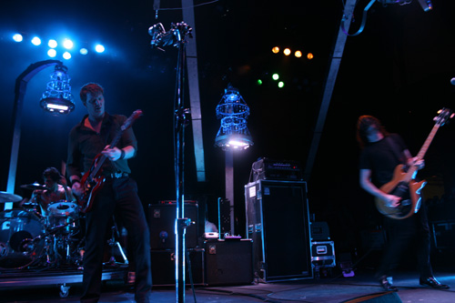 Queens of the Stone Age; Pacific Amphitheatre in Costa Mesa, CA.; July 22: Queens of the Stone Age headlined a perfect show at the fair-adjacent amphitheatre, one of those concerts you go to when youaE™re a kid. It was strongly reminiscent of that time your mom dropped you and your friends off in the parking lot, and your friend Nick pulled the two bottles of wine out of his backpack, and then you totally kissed that pretty girl, but lost track of her and never saw her again. The Queens finally arrived on stage with a fantastically creepy stage setup of lightshow chandeliers in haunted mansion style, and by this time, the crowd was sufficiently amped. Homme, still suffering from a serious knee injury hobbled across the stage, cane and guitar in hands. He made the most of it, however, by showcasing his very own, one-legged spin move. He exclaimed that despite his doctoraE™s recommendations, he couldnaE™t miss out on his aEœOrange Crush.aE Aww shucks. (Conor Izzett)Read the entire review here.Link to  slideshow.