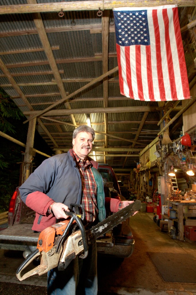 Tim Sheldon shows off the “toys” he stores in the shed he built on his Mason County tree farm.