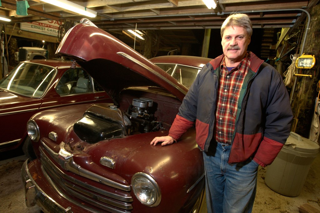 Tim Sheldon shows off the “toys” he stores in the shed he built on his Mason County tree farm.
