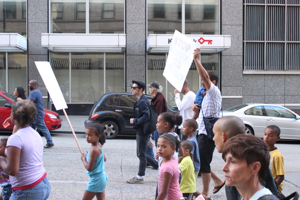 A young boy in a Huskies t-shirt tugs at the sleeve of