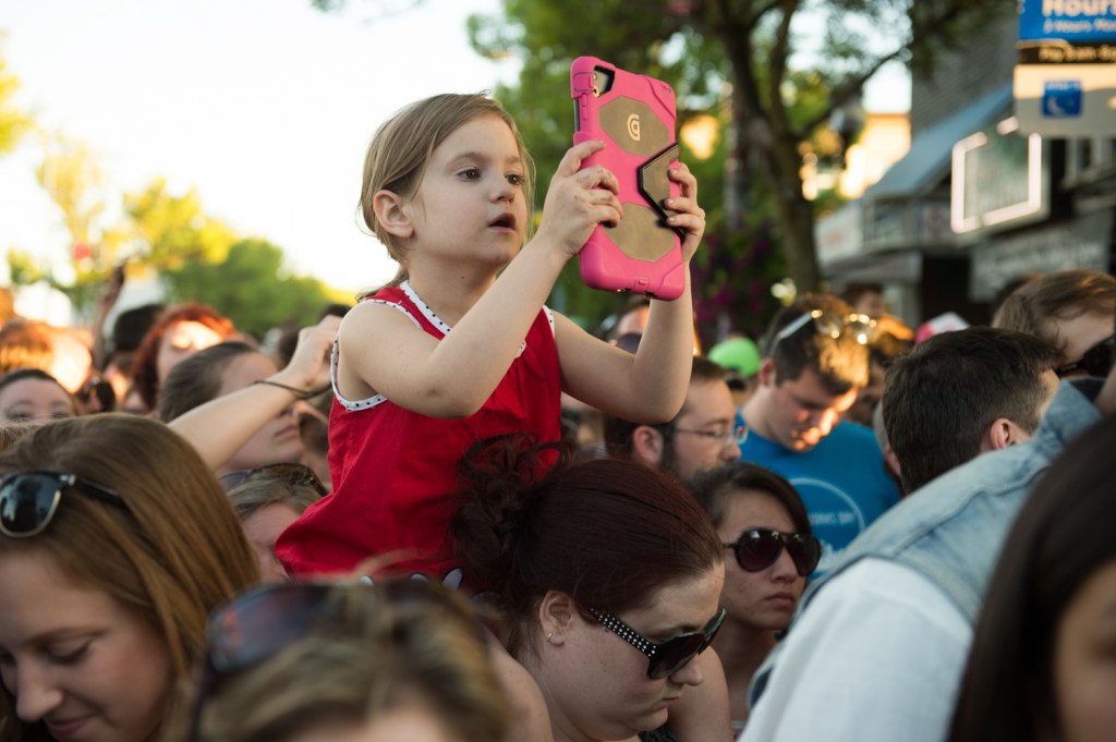 A young fan learning to annoy the masses with iPad photo taking at a very tender age.