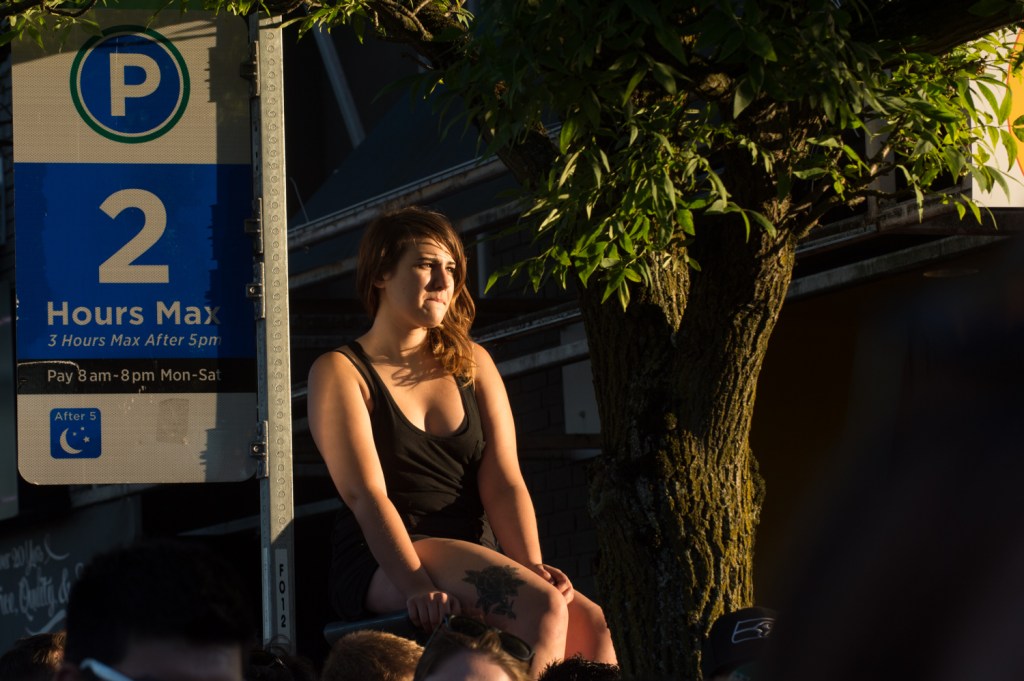 A Macklemore fan sits atop a parking meter.