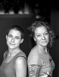 Dressed all in black, shaped by a smart blazer, a smiling John