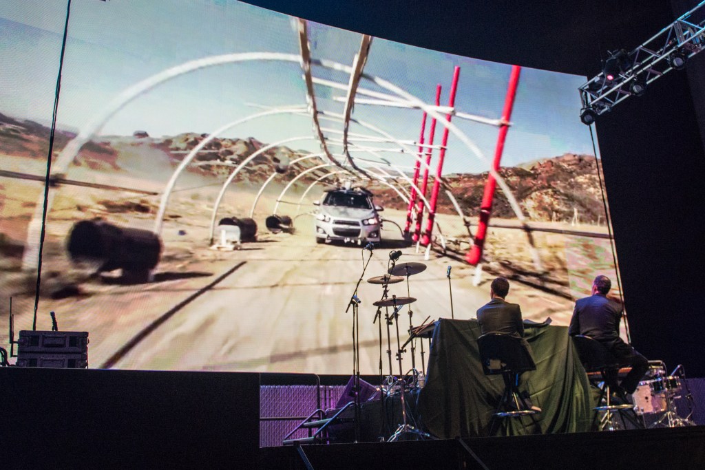 Damien Kulash and Jason Emmons look on as they play Ok Go's video for "Needing/Getting"