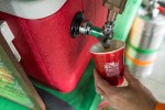A red ceramic cup emblazoned with the Bacon and Beer Classic's logo is filled at Sierra Nevada's booth.