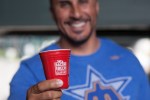 An attendee holds up the red ceramic cup given out to attendees of Saturday's Bacon and Beer Classic at Safeco Field.