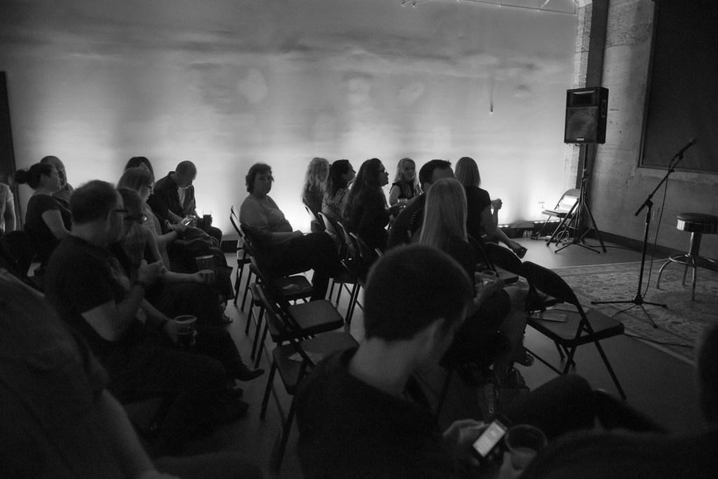 Audience quietly buzzing in anticipation of the slideshow to begin