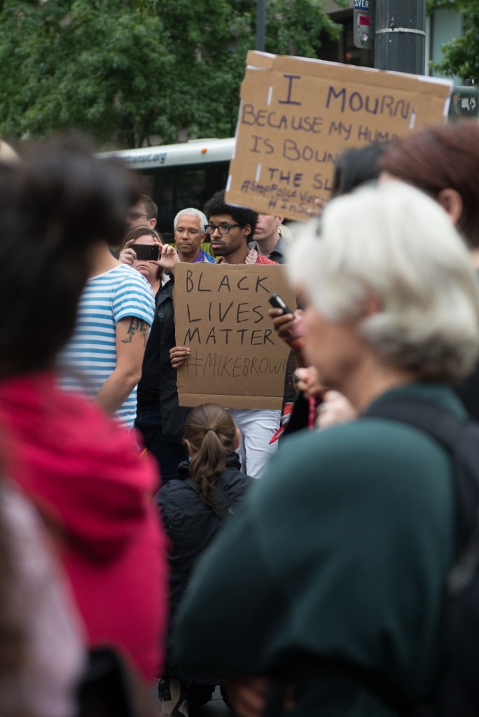 Many people gathering at Westlake Center brought signs to express themselves during the silent vigil. Photo by Morgen Schuler