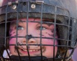 Helmet on and ready to ride, a little girl poses for a picture for her parents.