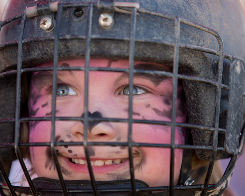 Helmet on and ready to ride, a little girl poses for a picture for her parents.