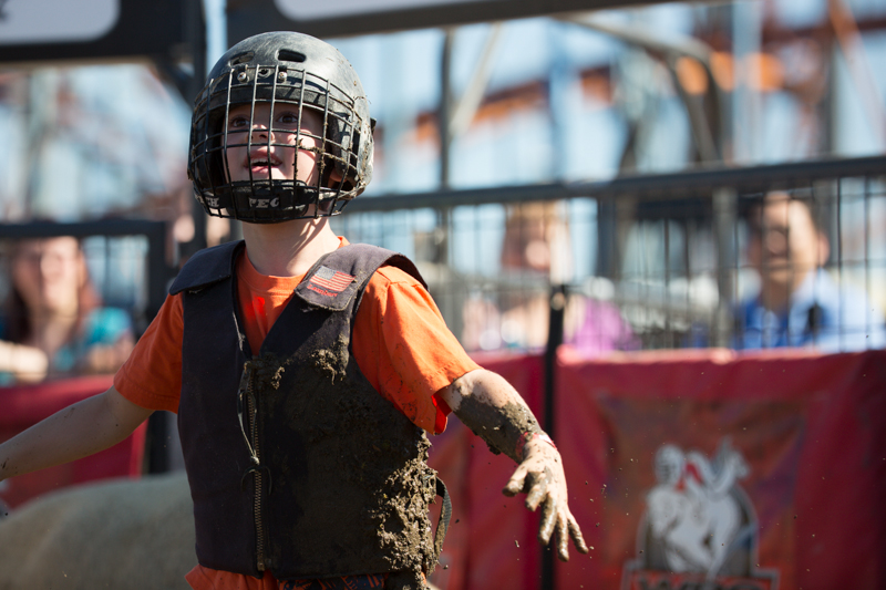 A child is all smiles, and mud, after his run.