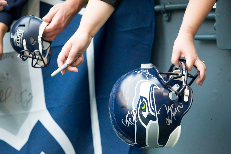 Seattle fans hold out helmets for autographs before the game.