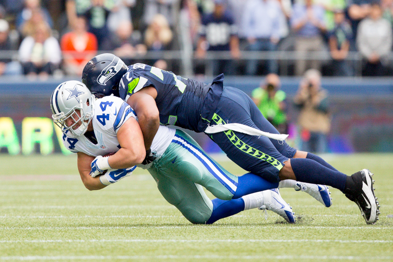Dallas fullback Tyler Clutts completes a 1-yard catch as he's tackled by Seahawks' defensive end Michael Bennett in the third quarter.