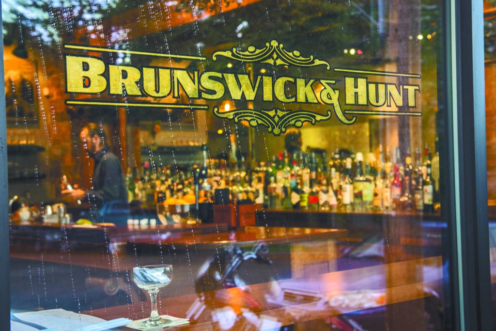 A circa-1900 landscape painting reflected in the beautiful bar. Below left: duck au poivre. Below right: oxtail with pasta.