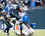 Seattle cornerback Richard Sherman leaps over Raider tight-end Mychal Rivera after intercepting a pass in the second quarter.