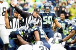 A referee indicates a Seattle possession after Raiders' TJ Carrie fumbled the ball atthe Oakland 25 in the second quarter.