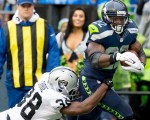 Seattle running back Robert Turbin is tripped up by Rainders cornerback TJ Carrie after a 14 yard run in the second quarter.
