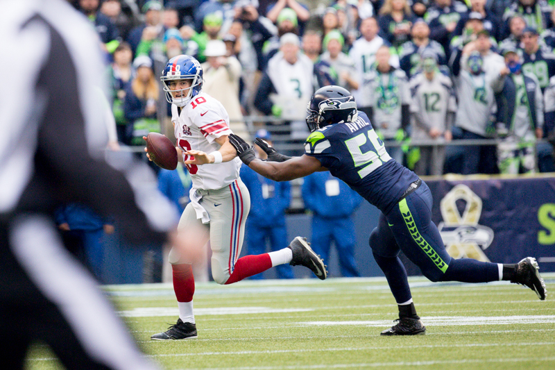 Giants quarterback Eli Manning is pressured by defensive end Cliff Avril into throwing an incomplete pass in the first quarter.