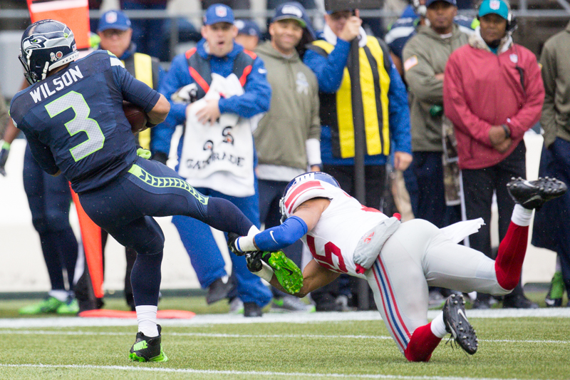Seattle quaterback Russell Wilson is stopped up by a Giant's defender after an 8 yard run in the first quarter.