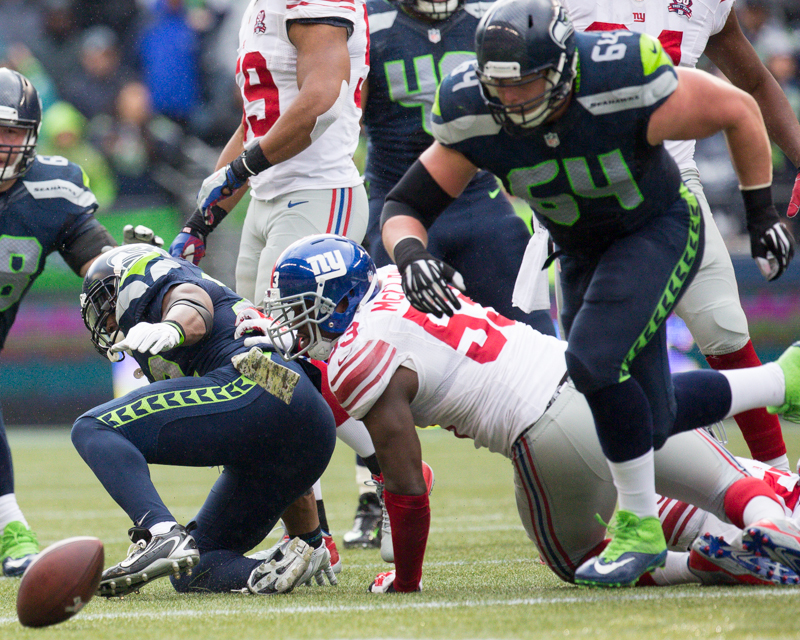 Players rush to grab hold of a fumbled ball by Seattle running back Robert Turbin in the second quarter. New York recovered the ball at the Seattle 47.