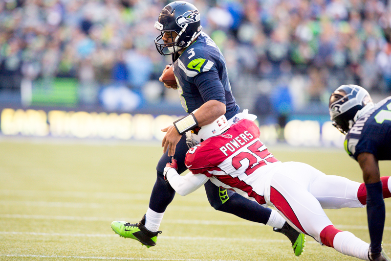 Russell Wilson is tackled by Arizona cornerback Jerraud Powers ona 15-yard pickup in the third quarter.