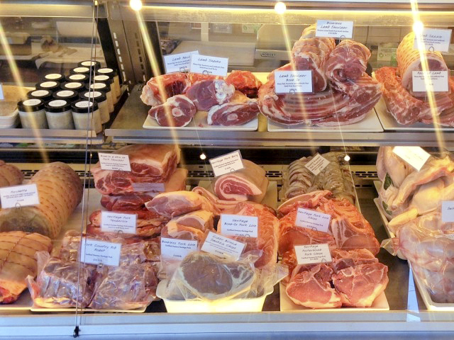 Standing at the door of the walk-in curing chamber at the Fatted