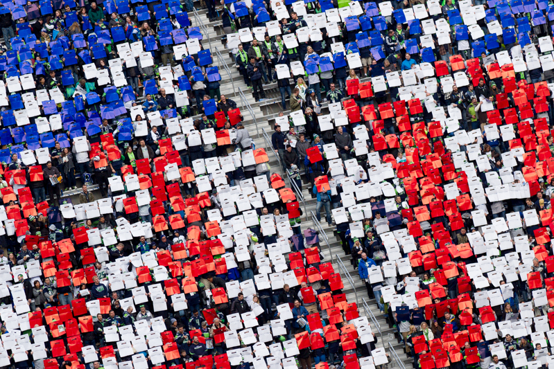 Holding up colored pieces of paper, fans in the famed Hawks Nest recreate the American flag for the singing of the National Anthem.