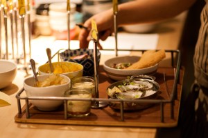 Top: dishes presented via trays. Bottom left: mussels in coconut milk. Bottom right: poached shrimp and broccoli with a punch.