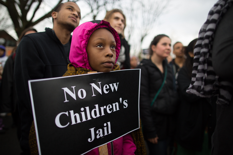 People listen to pre-march speakers at a rally outside Garfield High.