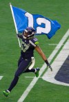 Linebacker Mike Morgan flies the 12th Man flag from the field before the game.