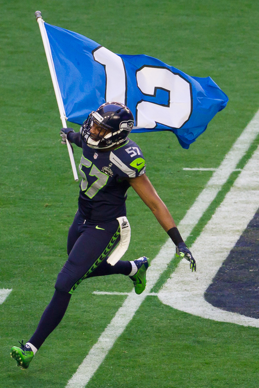 Linebacker Mike Morgan flies the 12th Man flag from the field before the game.