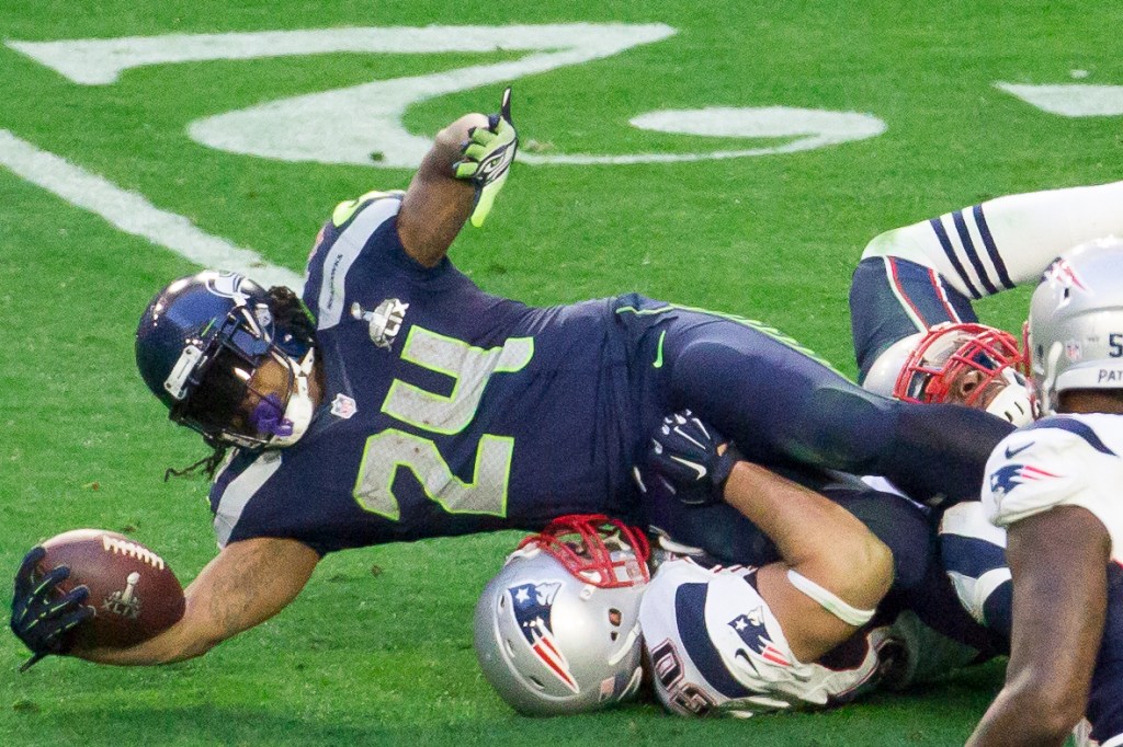 Marshawn Lynch reaches for extra yardage.