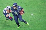 Russell Wilson scrambles away from a Patriots lineman.