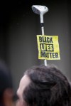 A woman holds a golf club with a "Black Lives Matter" sign during a Walking While Black: Always Dangerous Until Proven Otherwise protest on Capitol Hill Saturday, Feb. 7, 2015.
