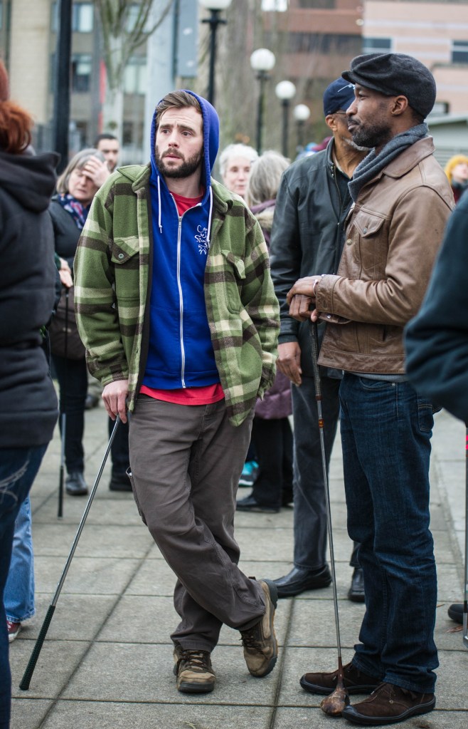 Protesters stand holding golf clubs before the Walking While Black: Always Dangerous Until Proven Otherwise protest starts Saturday afternoon. Around one hundred people met at Cal Anderson Park Shelterhouse on Capitol Hill for the protest.