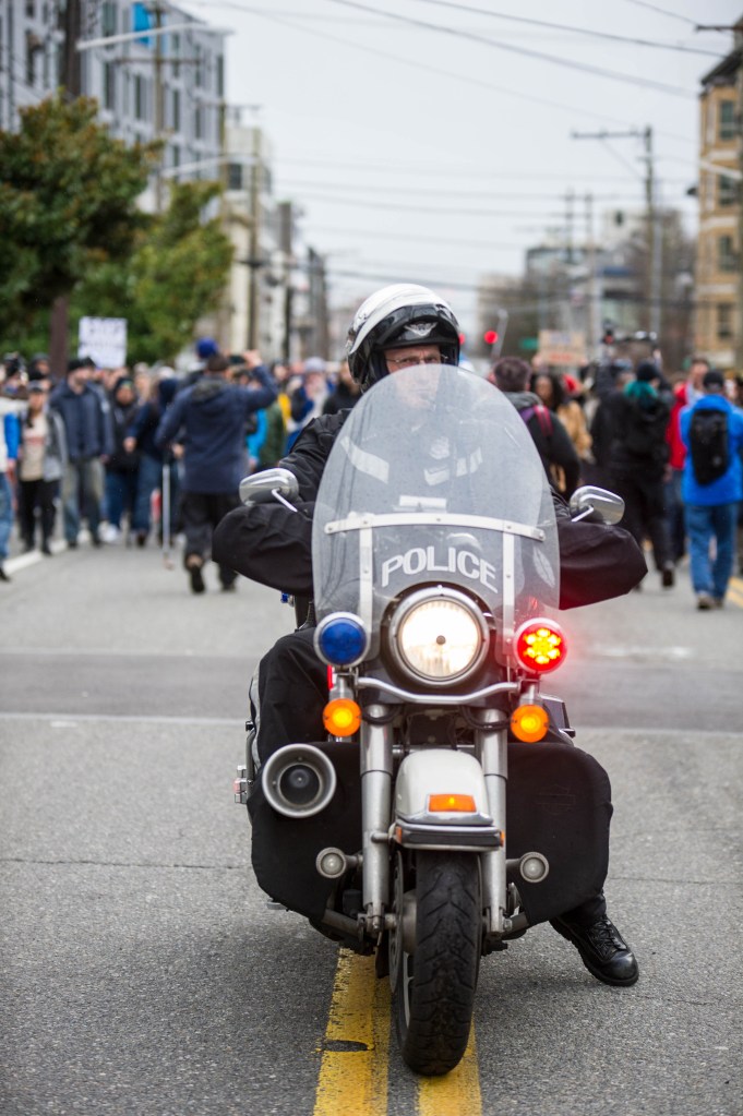 A Seattle police officer waits for protesters in the middle of the road. The SPD cleared the roads and conducted traffic during the Walking While Black march on Feb. 7, 2015 which protested racial profiling by Seattle police officers.