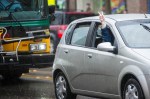 An onlooker throws up a peace sign, showing solidarity for those protesting in the Walking While Black: Always Dangerous Until Proven Otherwise march throughout Capitol Hill, Saturday afternoon. People marched to protest racial profile by Seattle Police.