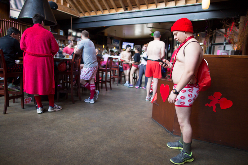 Clad in full Valentine's Day attire, a man checks his phone while waiting for the race to begin.