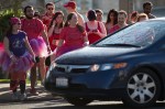 Runners wait for a car to pass before continuing.