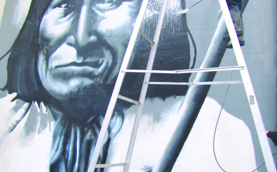 Geronimo stands strong as a worker scrubs away the vandal’s work.