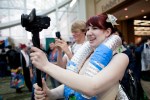 A woman records video of two fellow cosplayers.