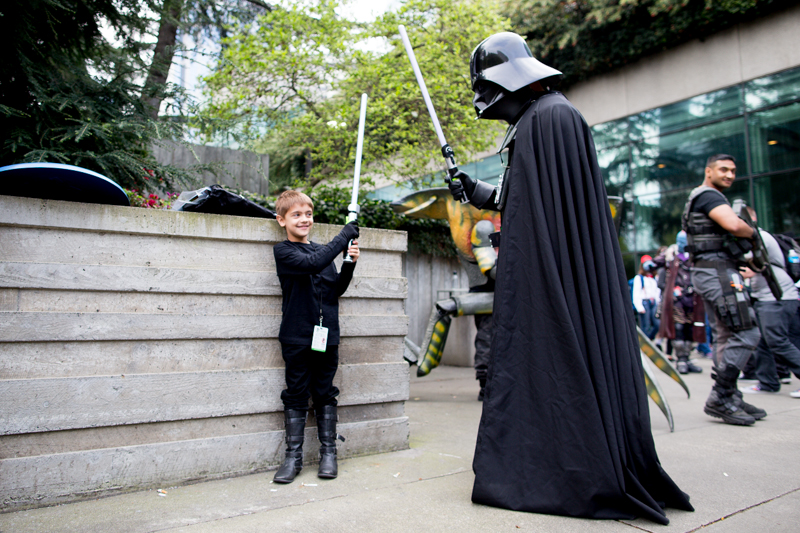 Ronan, six, battles his father, Darth Vader, in the park outside the convention center.