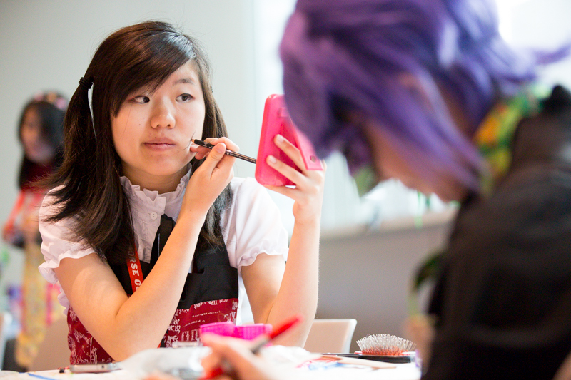 Louisa Fan touches up her makeup at a cosplay repair station.