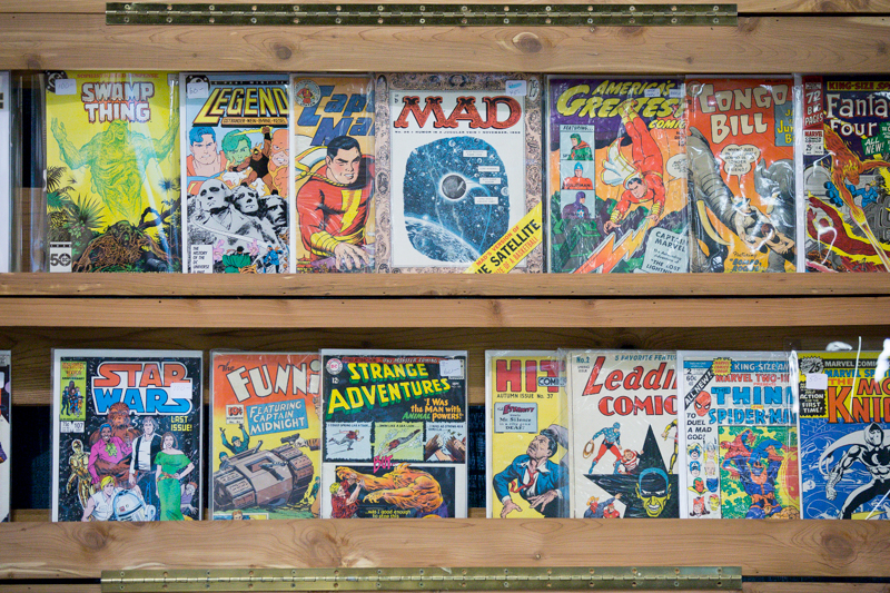 Retro comics adorn a shelf, ready for sale.
