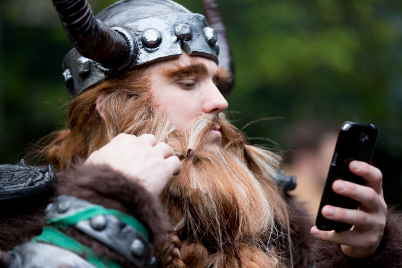 Using his cell phone as a mirror, Thomas Sergneri, aka Rawrbomb, adjusts his beard during a break.
