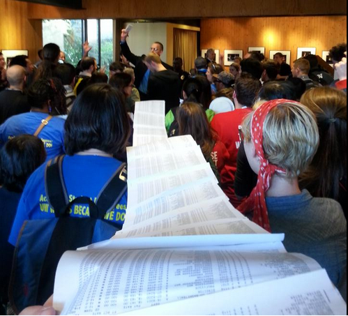 Protest hold up a list of all UW staff making over $150,000. Photo by Casey Jaywork