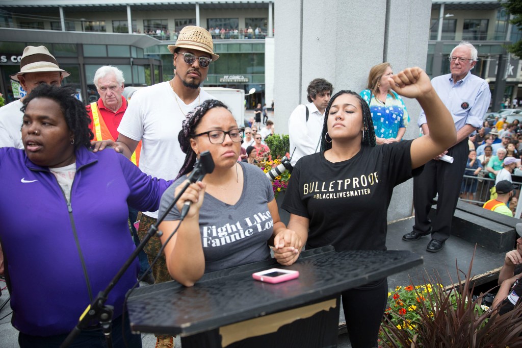 Marissa Janae Johnson, pictured at the microphone, says Democratic candidates for president still have work to do. Photo by Alex Garland