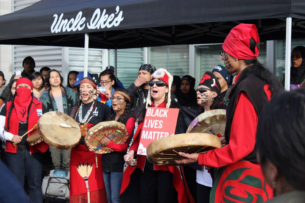 Indigenous activists sing outside Uncle Ike's. Photo by Casey Jaywork.